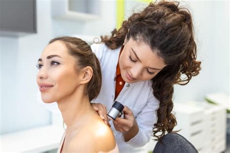 Dermatóloga examinando la piel en consulta